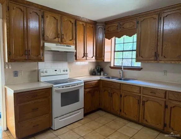 a kitchen with a stove sink and cabinets