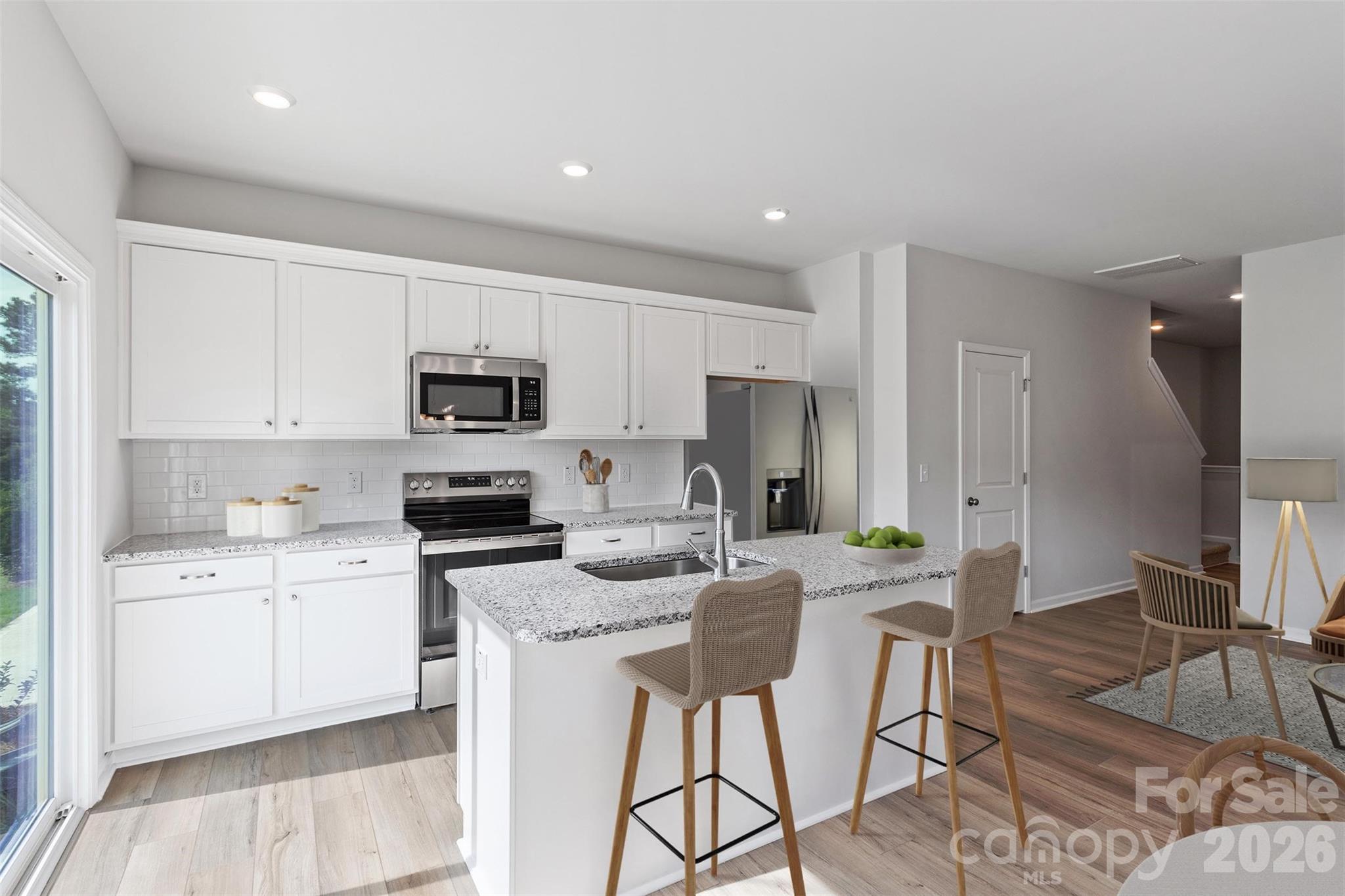 3017 Kingsfield Road, Unit 49 Charlotte, NC 28208 - Photo 6 of 10 a kitchen with stainless steel appliances granite countertop a stove top oven a sink a refrigerator and white cabinets with wooden floor