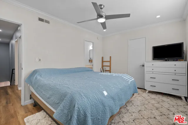 a bedroom with a bed and a flat tv screen on dresser