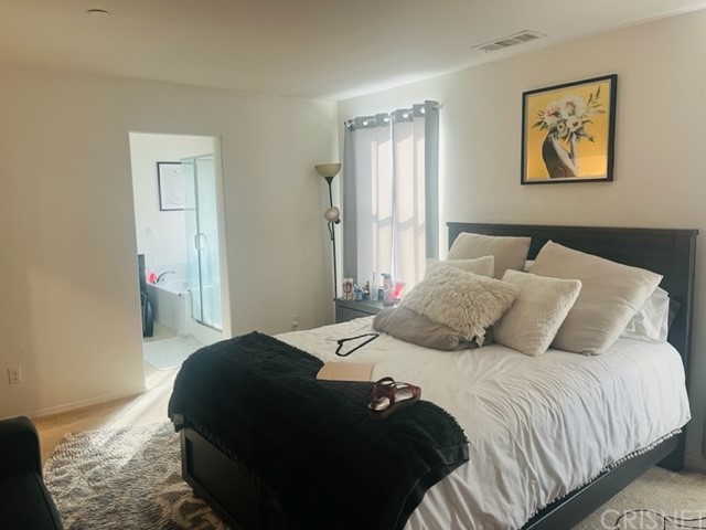 610 West Woodcrest Street Rialto, CA 92376 - Photo 13 of 33 a bedroom with a bed and painting on the wall