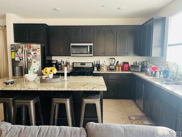 610 West Woodcrest Street Rialto, CA 92376 - Photo 6 of 33 a kitchen with stainless steel appliances granite countertop a sink a stove and cabinets