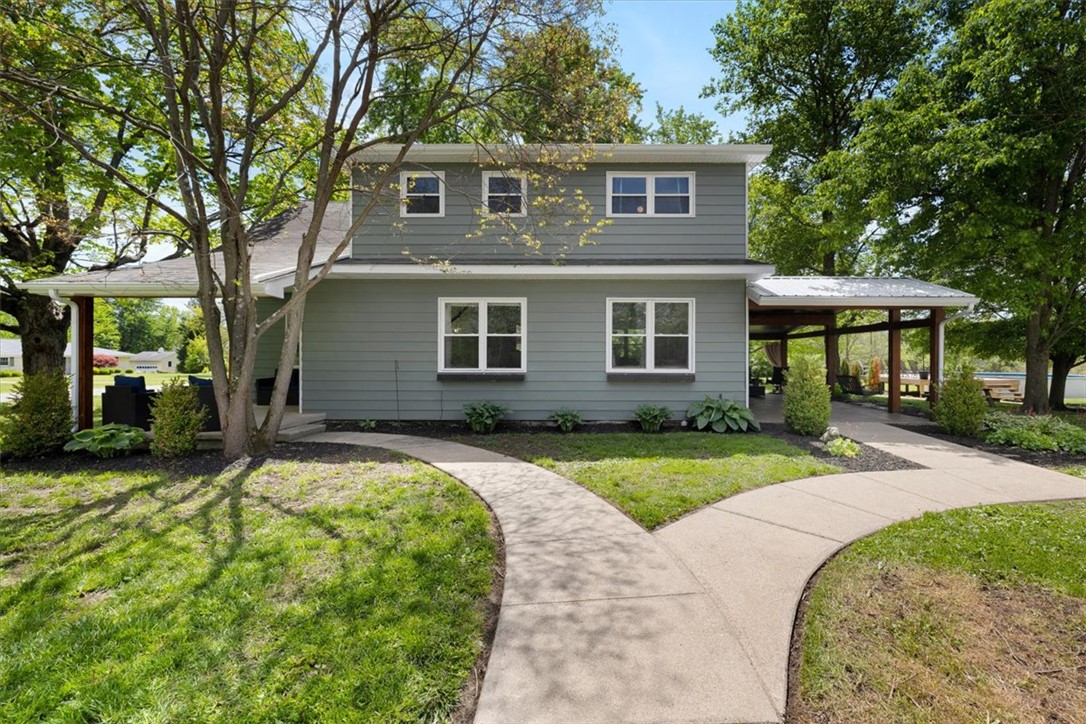 This residence features durable shingle siding, a well-maintained lawn, and mature trees enhancing its curb appeal.