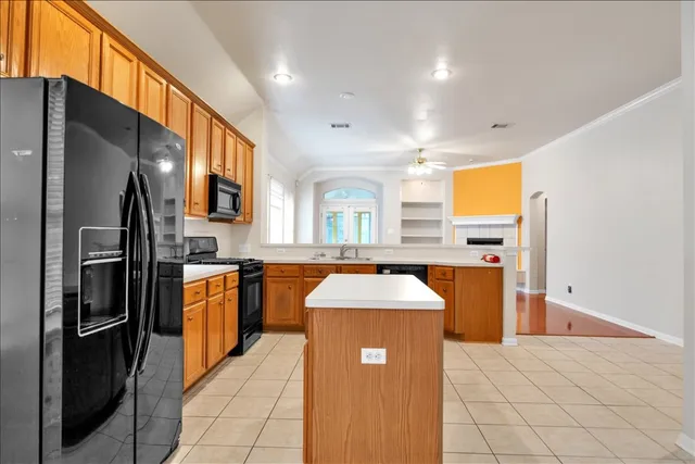 a kitchen with stainless steel appliances granite countertop a refrigerator a stove and a sink