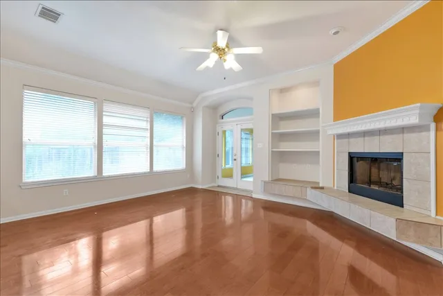 a view of an empty room with a window and fireplace