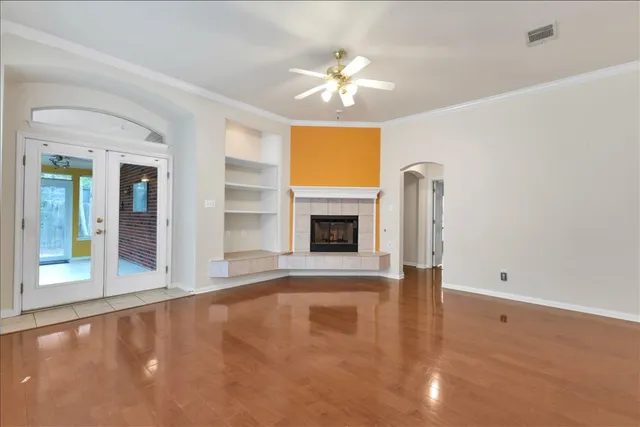 an empty room with a fireplace and chandelier