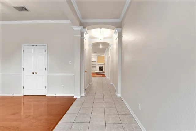 a view of a hallway with wooden floor and a bathroom
