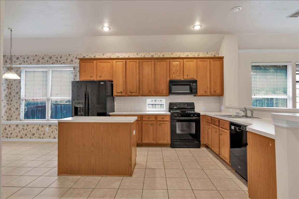 9237 La Siesta Bend Austin, TX 78749 - Photo 7 of 29 a kitchen with stainless steel appliances granite countertop a stove top oven a sink and a refrigerator