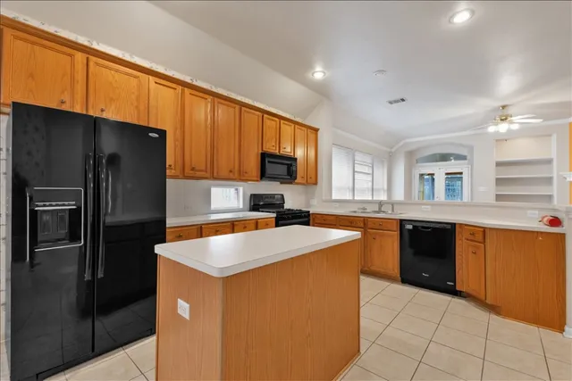 a kitchen with stainless steel appliances granite countertop a refrigerator stove top oven and sink
