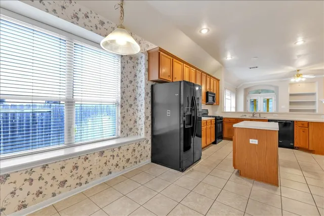 a kitchen with stainless steel appliances granite countertop a refrigerator and a stove