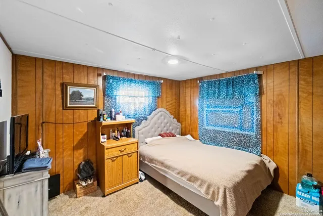a bedroom with a bed and a flat tv screen on the dresser