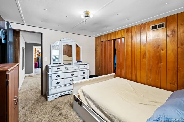 a spacious bedroom with a bed and a dresser