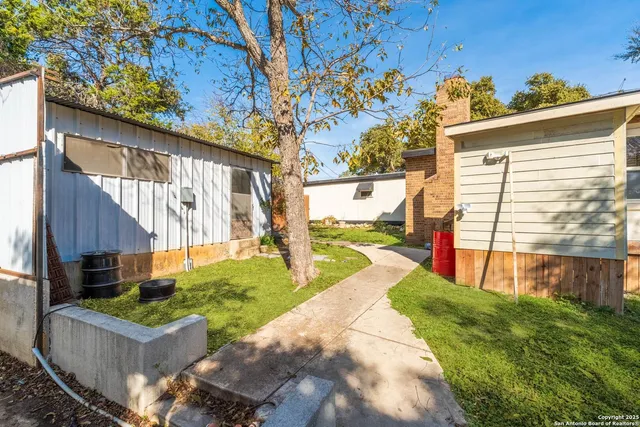 a view of a house with backyard and sitting area
