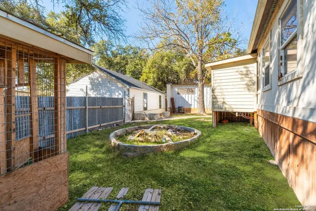 a view of a backyard with sitting area and garden