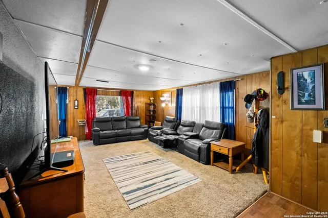 a living room with furniture a rug and a flat screen tv