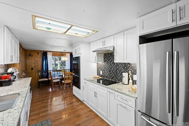 a kitchen with stainless steel appliances granite countertop a refrigerator and a sink