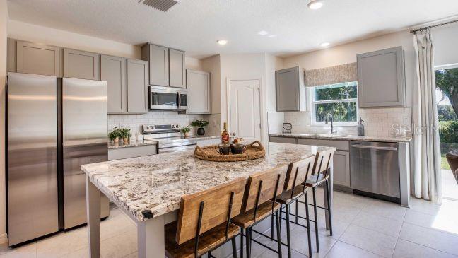 3592 Summitview Drive Lakeland, FL 33803 - Photo 4 of 23 a kitchen with granite countertop a center island and stainless steel appliances