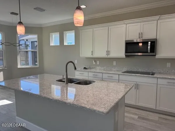 a kitchen with stainless steel appliances granite countertop a sink a microwave and cabinets