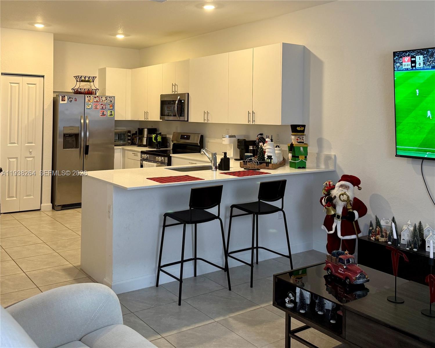 23049 Southwest 129th Place Miami, FL 33177 - Photo 8 of 33 a kitchen with stainless steel appliances a sink a refrigerator and a dining table
