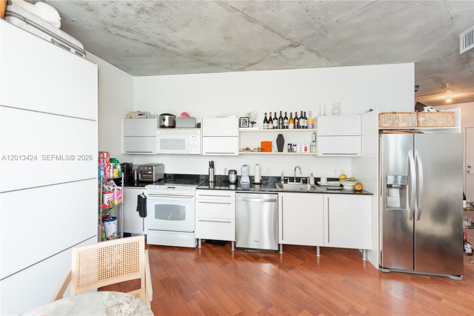 690 Southwest 1st Court, Unit 1034 Miami, FL 33130 - Photo 7 of 12 a kitchen with stainless steel appliances a sink and a refrigerator