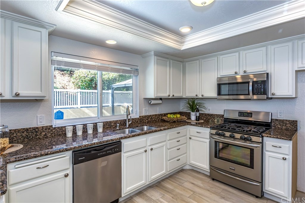 11 Silveroak Aliso Viejo, CA 92656 - Photo 6 of 41 a kitchen with granite countertop white cabinets appliances a window and a sink