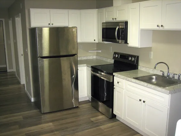 a kitchen with stainless steel appliances granite countertop a refrigerator a stove a sink and a microwave