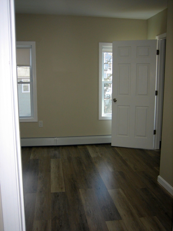 9 Pearl Street, Unit 2 Ayer, MA 01432 - Photo 5 of 10 an empty room with wooden floor and windows
