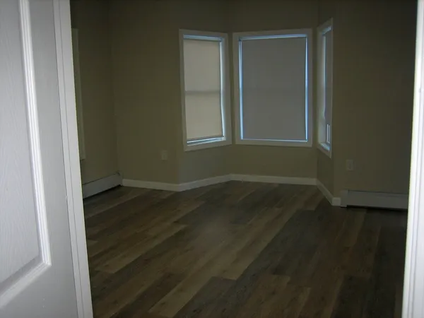 a view of a small space with wooden floor and a window