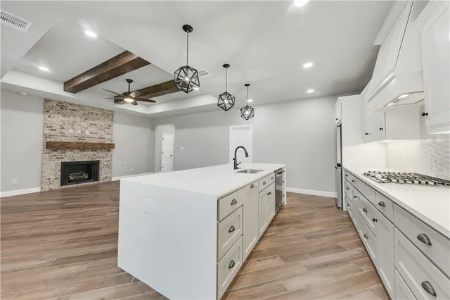 a large white kitchen with a stove top oven
