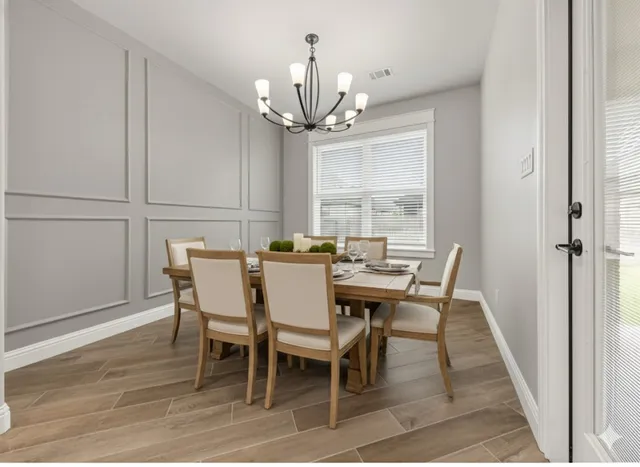 a view of a dining room with furniture a chandelier and wooden floor