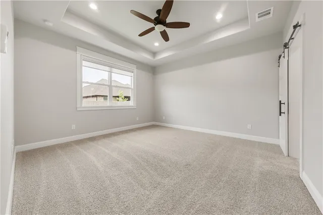 an empty room with windows and ceiling fan