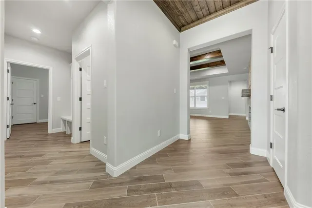 a view of a hallway with wooden floor and closet