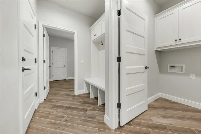 a view of a hallway with wooden floor and entryway