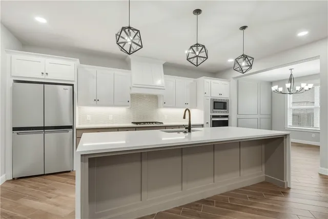 a kitchen with appliances cabinets and a table