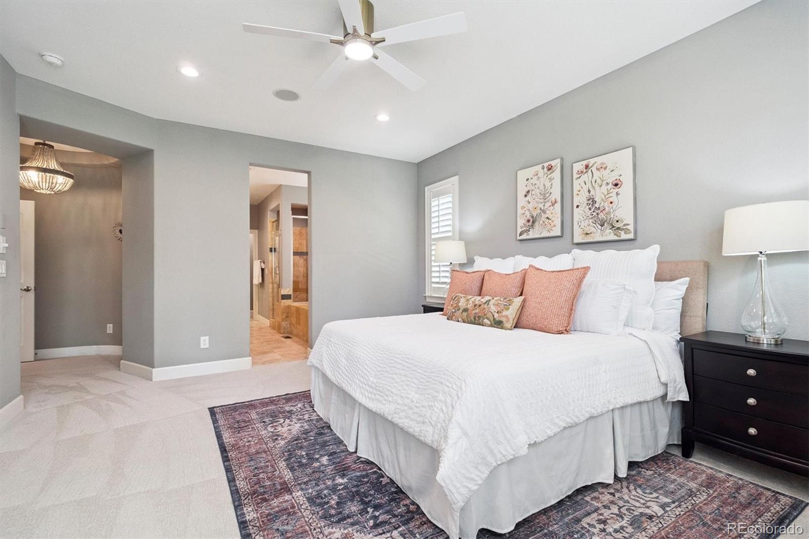470 Maplehurst Drive Highlands Ranch, CO 80126 - Photo 16 of 46 a spacious bedroom with a large bed and a chandelier