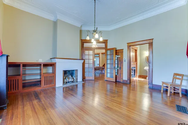 a view of a livingroom with furniture wooden floor fireplace and windows