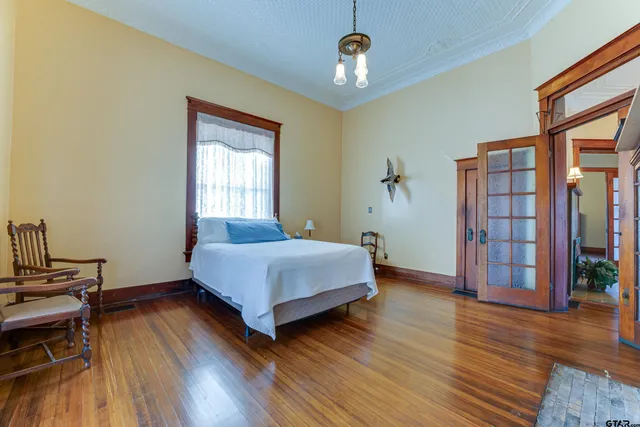 a spacious bedroom with a bed and wooden floor