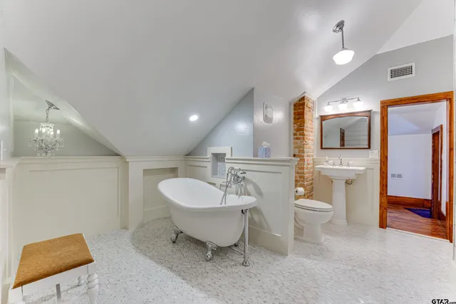 a spacious bathroom with a toilet sink and mirror