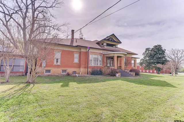 a front view of a house with a garden and swimming pool