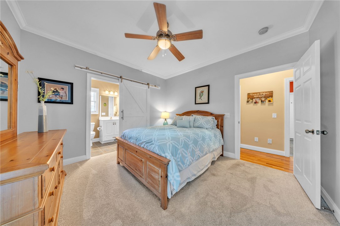 648 Mountain View Road Williamston, SC 29697 - Photo 23 of 42 A well-lit bedroom with soft carpeting and a distinctive barn door leading to an en-suite bath.