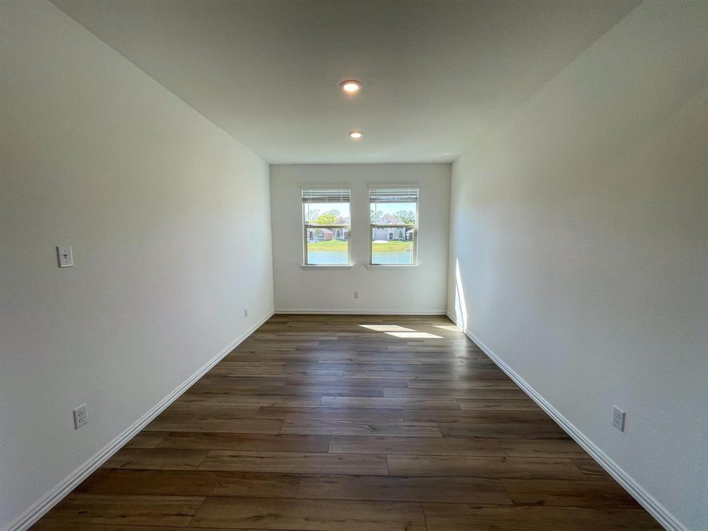 3305 Tulip Poplar Trail McKinney, TX 75071 - Photo 13 of 29 an empty room with wooden floor and windows