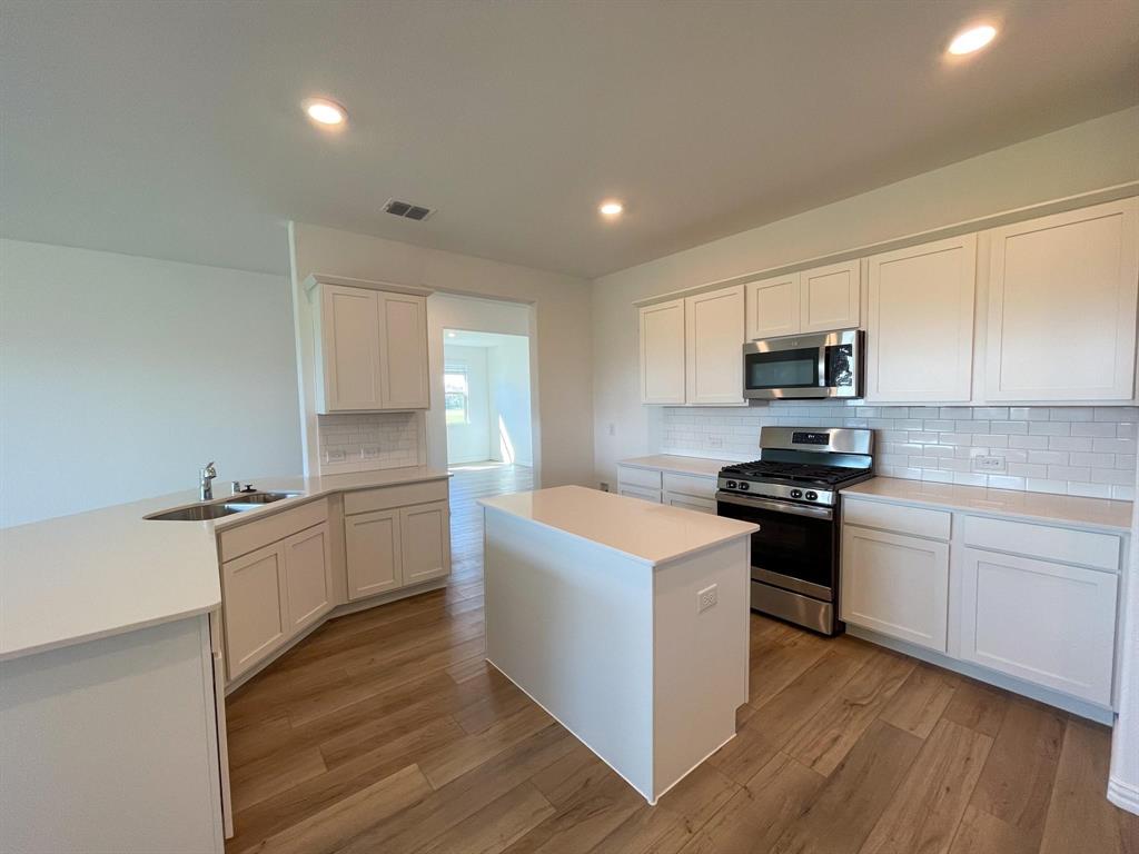 3305 Tulip Poplar Trail McKinney, TX 75071 - Photo 15 of 29 a kitchen with granite countertop white cabinets and white appliances