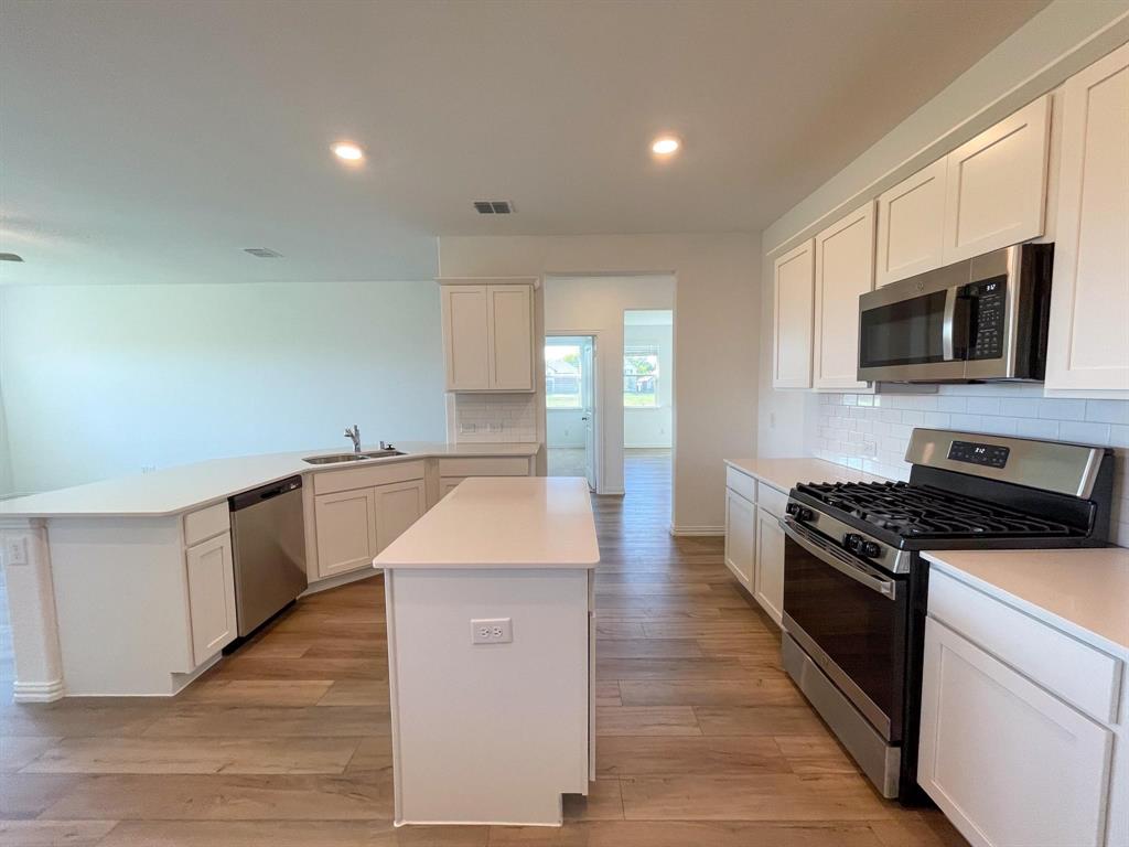 3305 Tulip Poplar Trail McKinney, TX 75071 - Photo 16 of 29 a kitchen with a sink and steel appliances