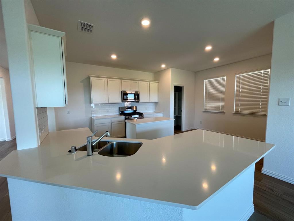 3305 Tulip Poplar Trail McKinney, TX 75071 - Photo 17 of 29 a kitchen with a table chairs sink and refrigerator