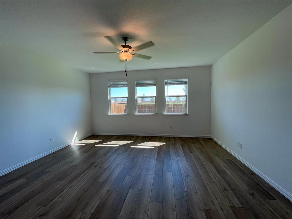 3305 Tulip Poplar Trail McKinney, TX 75071 - Photo 18 of 29 a view of an empty room with wooden floor and a window