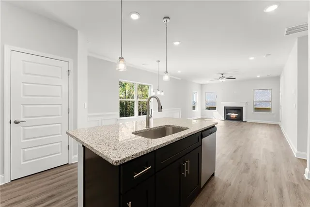 a kitchen with a sink stove and wooden floor