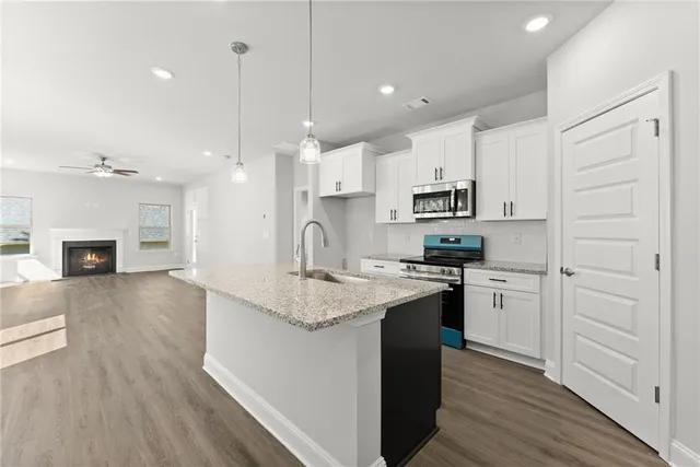a kitchen with kitchen island a sink stainless steel appliances and cabinets