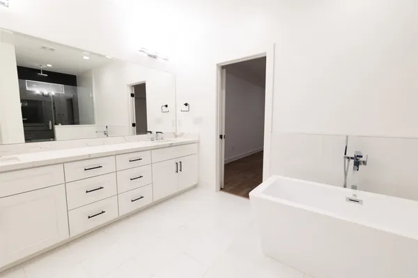 a spacious bathroom with a tub sink and mirror