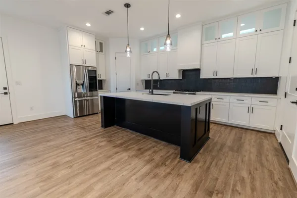 a kitchen with stainless steel appliances granite countertop a sink a stove and a refrigerator