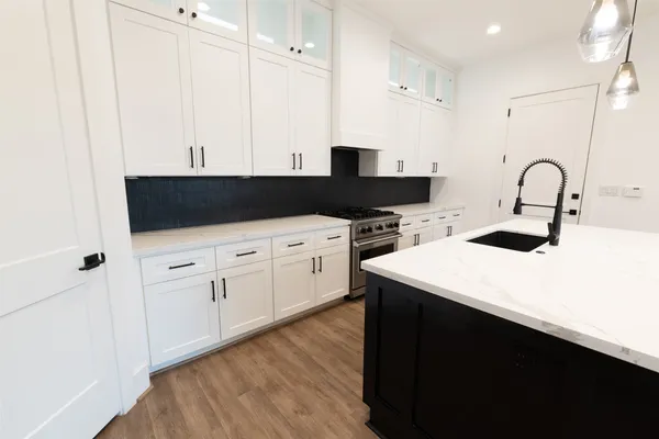 a kitchen with a sink a stove and cabinets
