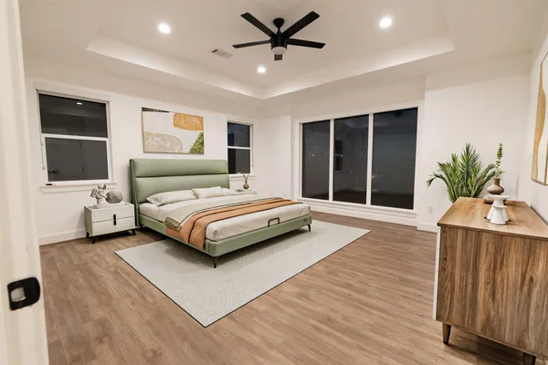a bedroom with a large bed and a potted plant